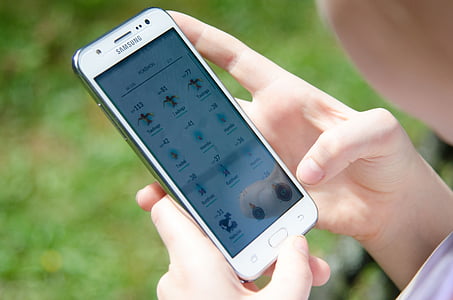 woman holding white Samsung Android smartphone thumbnail