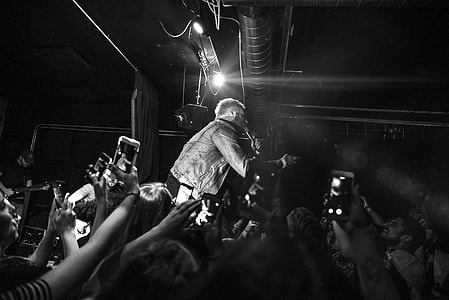 grayscale photo of man singing on stage thumbnail