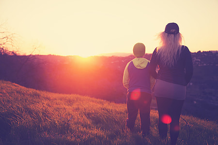 woman and child standing on top of mountain thumbnail