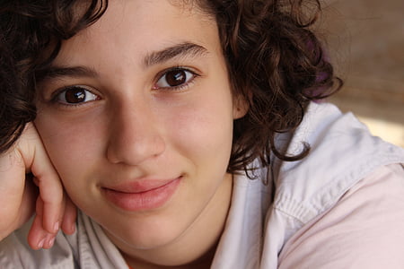 woman with curly hair in white hoodie thumbnail