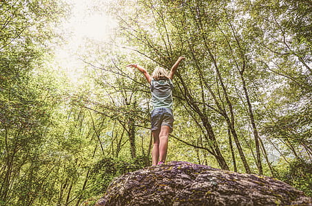 Photo of Girl Standing on Rock Raising Her Hands thumbnail
