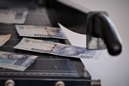 100 banknote placed on paper cutter thumbnail