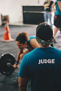 Man in Blue Crew-neck Shirt Staring At Woman Trying To Lift Barbell thumbnail