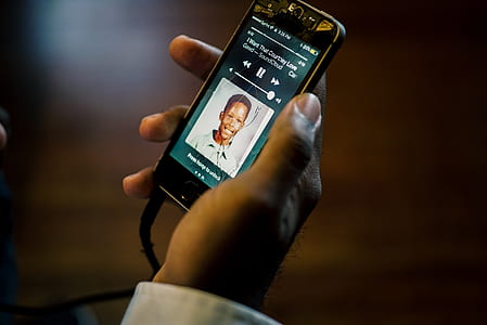 person holding black smartphone shallow focus photography thumbnail