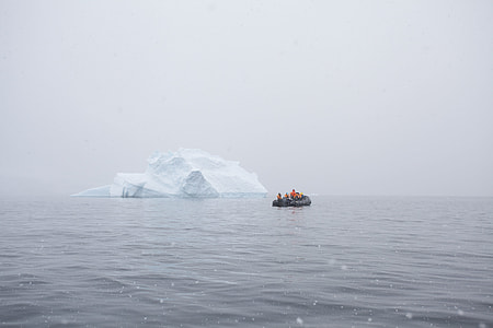 black inflatable boat near white iceburg thumbnail