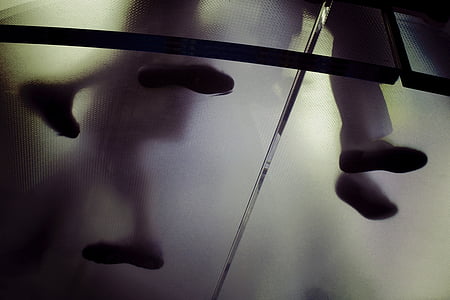 low angle photography of person standing on glass floor inside building thumbnail