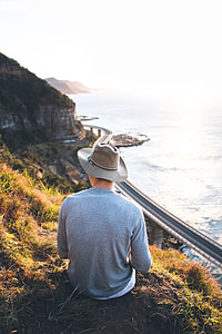 man sitting on the grass wearing hat and long sleeves shirt thumbnail