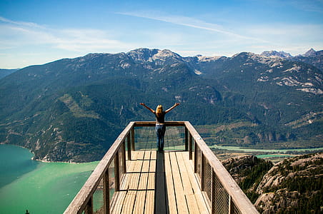 Person in Wooden Balcony Overlooking Mountains thumbnail