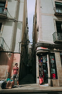 Man Wearing Red Shirt Standing Near a Concrete Structure thumbnail