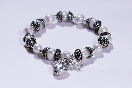 white pearl necklace on white surface thumbnail
