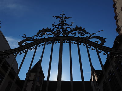 low angle photography of black gate under blue sky during daytime thumbnail