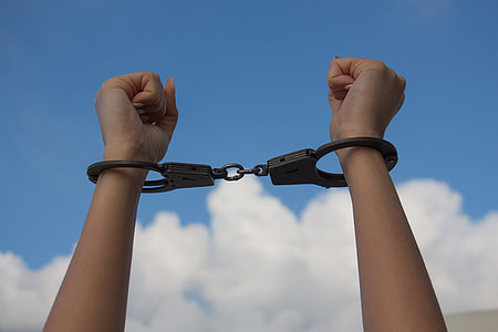 closeup photo of person raising hands while handcuffed thumbnail