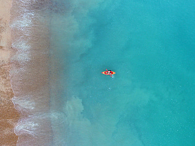 person riding kayak near brown sea shore thumbnail