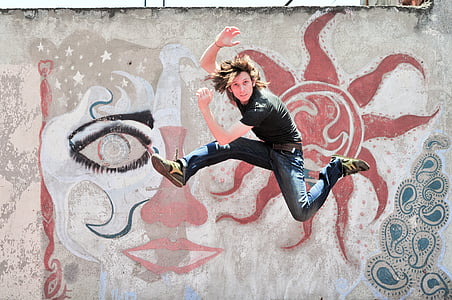 man wearing blue jeans jumping and posing while in air thumbnail