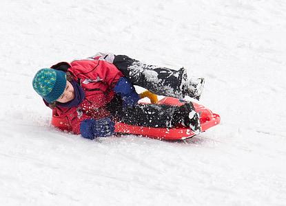 two children playing sled on snow thumbnail