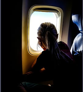 girl watching on skies near airplane window thumbnail