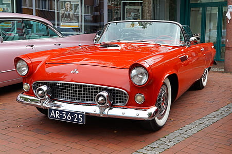 red coupe parked near building at daytime thumbnail