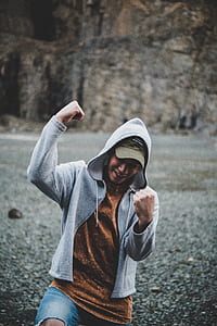 man wearing hoodie showing both fist thumbnail
