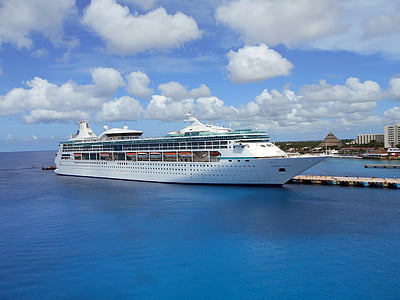 white cruise ship near dock under gray and blue skies thumbnail