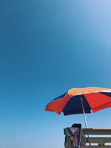 Person Sitting on Bench Under Umbrella thumbnail