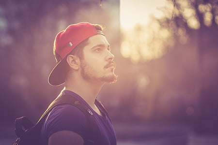 man wearing red flat-brim cap in tilt shift lens shot thumbnail