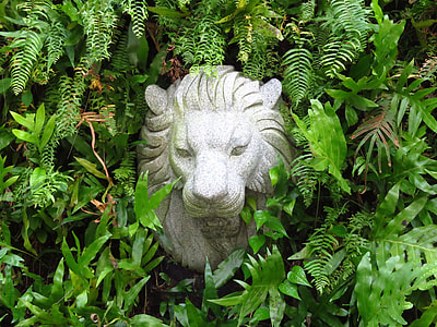 gray lion concrete outdoor decor surrounded by plants thumbnail