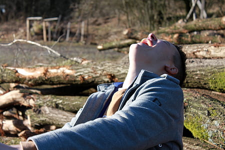 man laughing while sitting on ground thumbnail