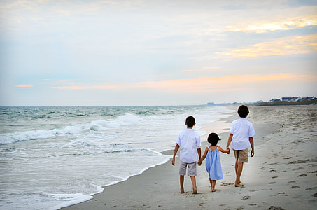 three children walking beside beach thumbnail