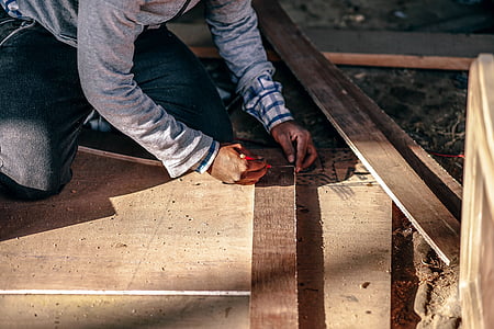 man nailing wooden panel thumbnail
