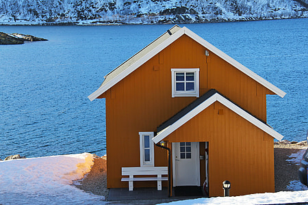 white and brown wooden house on sea side thumbnail