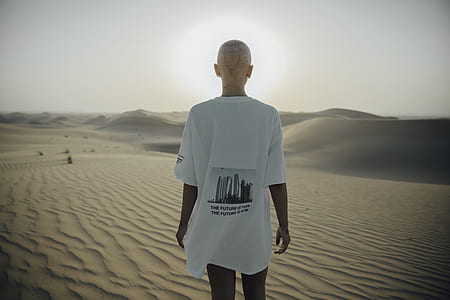 person walking on desert sand during daytime thumbnail