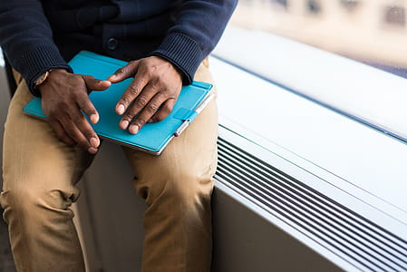 Person Holding Blue Book thumbnail