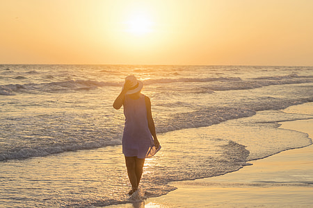 woman walking in seashore in golden hour thumbnail