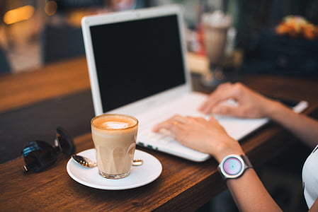 person using white laptop beside coffee latte thumbnail
