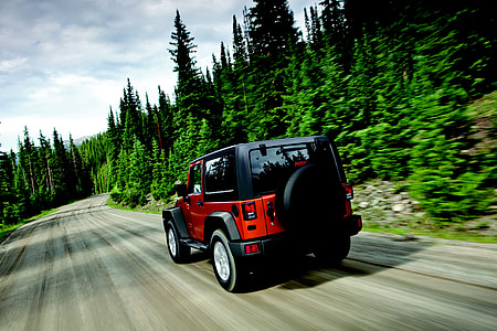 red Jeep Wrangler near the trees thumbnail