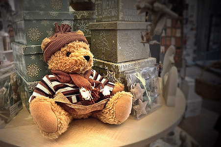 brown teddy bear beside boxes on top of table thumbnail