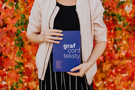Girl with the Grafconf book on the background of colourful leaves thumbnail