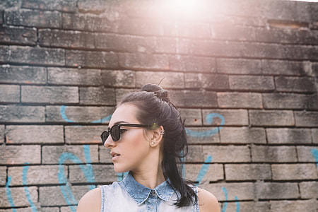 woman standing near brick wall thumbnail