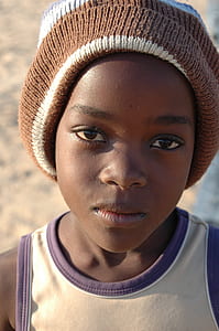 close-up photo of child in brown knit cap thumbnail