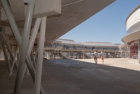 two person standing in the middle of grey concrete building thumbnail