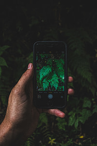 person hand holding space gray iPhone in camera mode thumbnail