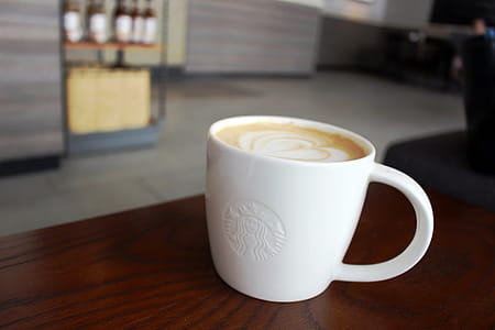 Cup of hot coffee in Starbucks with logo on the cup. Editorial use. thumbnail