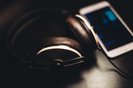 selective focus photography of corded headphones beside smartphone thumbnail