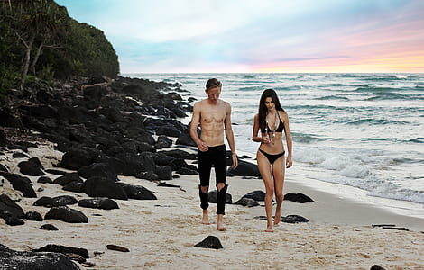 man and woman walking on seashore thumbnail