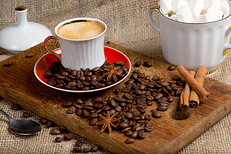 white ceramic coffee cup on saucer beside coffee beans thumbnail