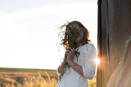 woman covering her face using plant thumbnail