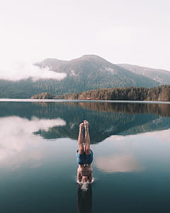 person in blue shorts diving on body of water thumbnail