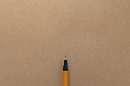 yellow ballpoint pen on beige surface thumbnail