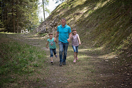 man with two girls standing on field thumbnail