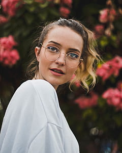 woman wearing eyeglasses standing near flower thumbnail